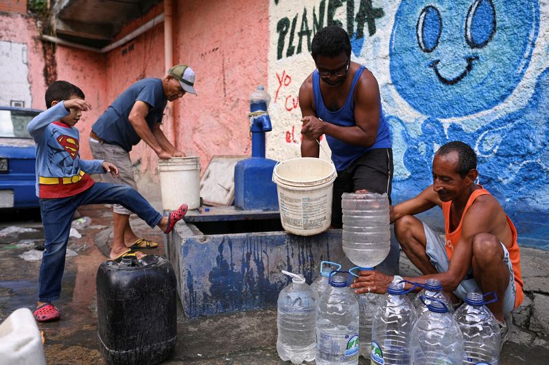 &copy; Reuters. FILE PHOTO: People extract water from an unknown source in the low-income neighborhood of Petare, in Caracas, Venezuela May 12, 2023. REUTERS/Gaby Oraa/File Photo