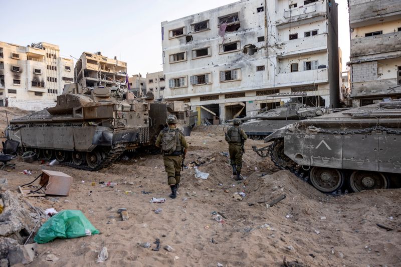 &copy; Reuters. Des soldats israéliens marchent dans les décombres, lors de l'invasion terrestre contre le groupe islamiste palestinien Hamas dans le nord de la bande de Gaza. /Photo prise le 8 novembre 2023/REUTERS/Ronen Zvulun