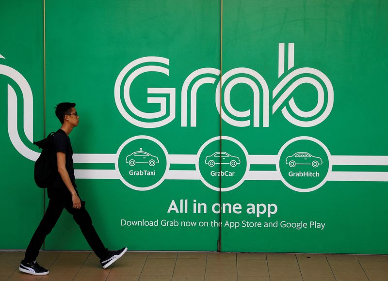 &copy; Reuters. FILE PHOTO: A man walks past a Grab office in Singapore March 26, 2018. REUTERS/Edgar Su