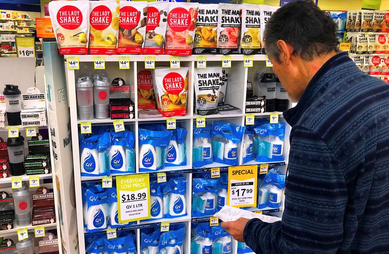 © Reuters. FILE PHOTO: A customer looks at products marked with discounted prices on display at a chemist in a shopping mall in central Sydney, Australia, July 25, 2018.    REUTERS/David Gray/File Photo/File Photo