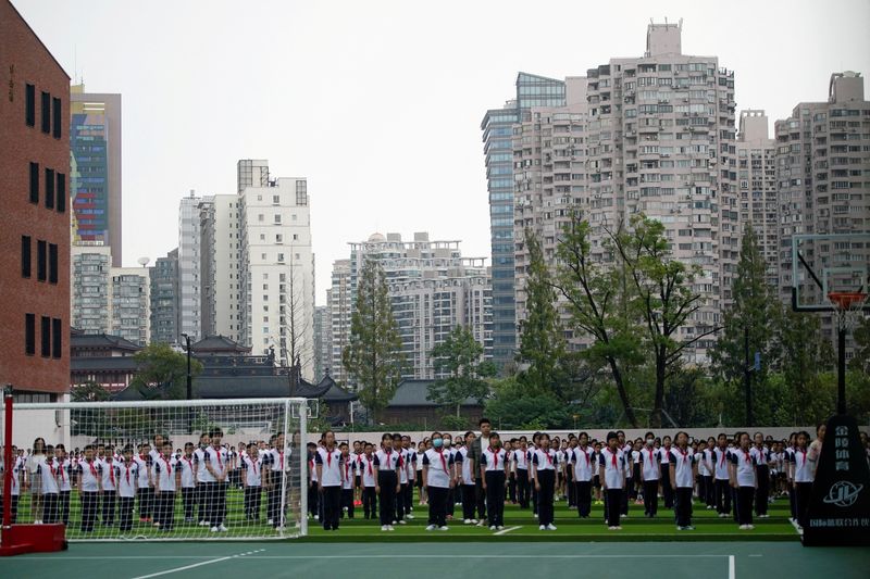 &copy; Reuters. FILE PHOTO: Students stand at a school during a flag-lowering ceremony on the first day of the new academic year in Shanghai, China, September 1, 2021. REUTERS/Aly Song