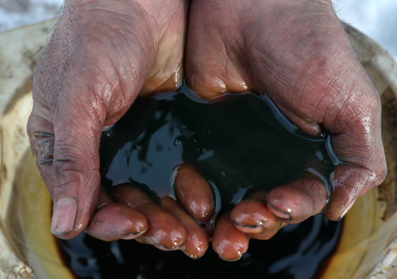 &copy; Reuters. Del petrolio greggio nelle mani di un operaio a Irkutsk in Russia. 11 marzo 2019. REUTERS/Vasily Fedosenko/Illustration