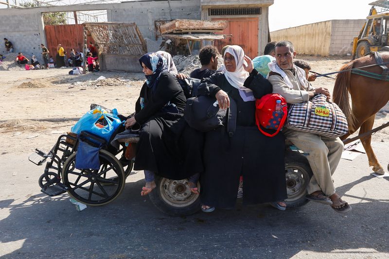 &copy; Reuters. فلسطينيون في طريقهم إلى جنوب غزة وسط الصراع المستمر بين إسرائيل وحماس وسط مديتة غزة يوم الجمعة. تصوير رويترز.