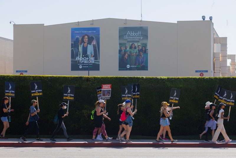 © Reuters. SAG-AFTRA actors and Writers Guild of America (WGA) writers walk the picket line outside Disney Studios in Burbank, California, U.S., July 25, 2023. REUTERS/Mike Blake