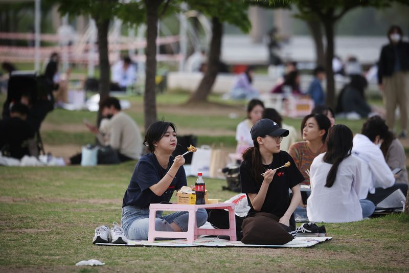&copy; Reuters. Women eat fried chicken at a Han river park in Seoul, South Korea, April 26, 2022. Picture taken April 26, 2022. REUTERS/Kim Hong-Ji/File Photo