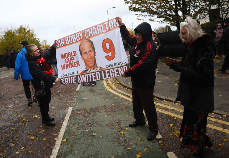 &copy; Reuters. Soccer Football - Funeral of former England and Manchester United footballer Bobby Charlton - Old Trafford, Manchester, Britain - November 13, 2023 Fans display a banner with the image of Bobby Charlton as they prepare to pay their respects outside Old Tr