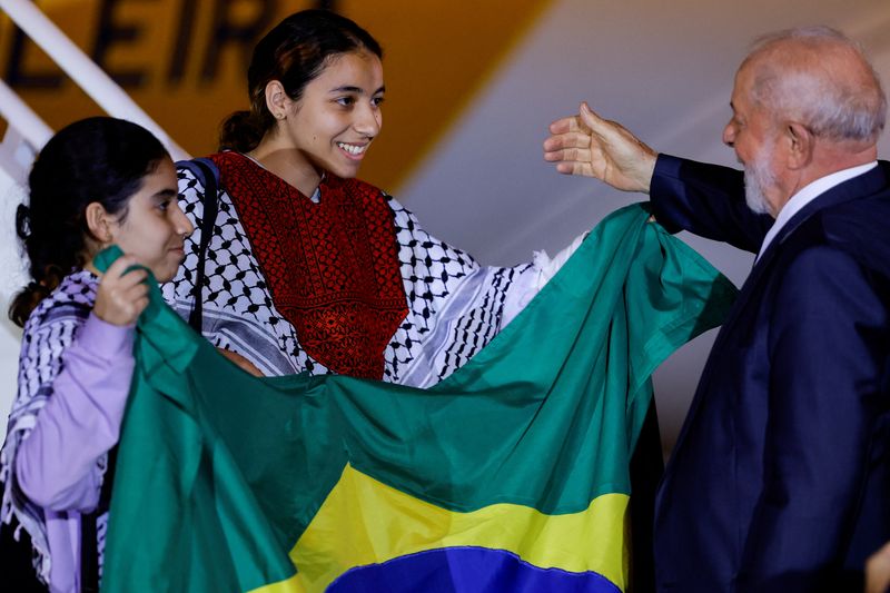 &copy; Reuters. الرئيس البرازيلي لويس إيناسيو لولا دا سيلفا يستقبل فتاتين لدى وصولهما إلى قاعدة برازيليا الجوية يوم الاثنين عقب عودتهما من قطاع غزة ضمن 32 م