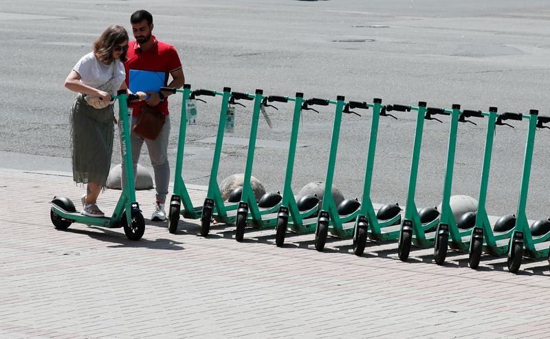 &copy; Reuters. FILE PHOTO: A woman tries to use an e-scooter from provider Bolt in central Kyiv, Ukraine June 30, 2021.  REUTERS/Gleb Garanich/File Photo