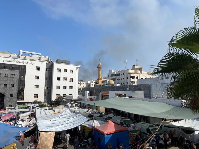 &copy; Reuters. دخان يتصاعد مع لجوء النازحين الفلسطينيين إلى مستشفى الشفاء في مدينة غزة في التاسع من نوفمبر تشرين الثاني 2023. تصوير: دعاء روقة - رويترز.