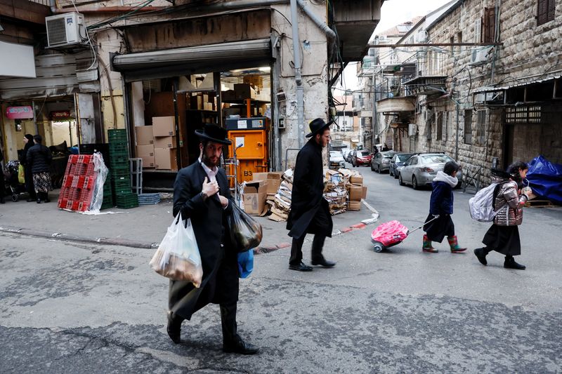 &copy; Reuters. FILE PHOTO: An Ultra-Orthodox Jewish man carries shopping bags on a commercial street in Jerusalem's Mea Shearim neighbourhood, January 2, 2023. REUTERS/Ammar Awad