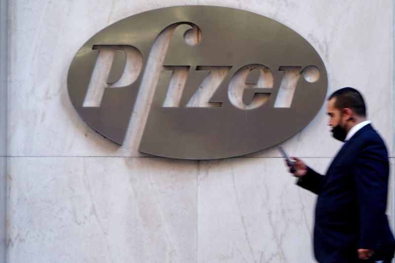 &copy; Reuters. FILE PHOTO: A person walks past the Pfizer Headquarters building in the Manhattan borough of New York City, New York, U.S., November 9, 2020. REUTERS/Carlo Allegri/File Photo