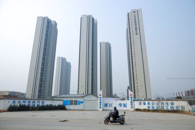 &copy; Reuters. A man rides a scooter past apartment highrises that are under construction near the new stadium in Zhengzhou, Henan province, China, January 19, 2019.  Picture taken January 19, 2019.  REUTERS/Thomas Peter/File Photo