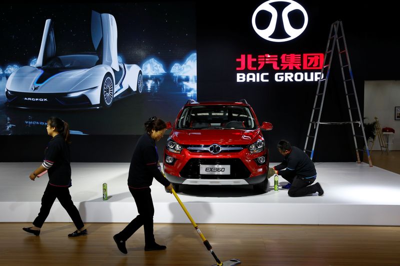 &copy; Reuters. People clean the floor at the stall of the BAIC Group automobile maker at the IEEV New Energy Vehicles Exhibition in Beijing, China October 18, 2018.  Picture taken October 18, 2018.   REUTERS/Thomas Peter/File Photo
