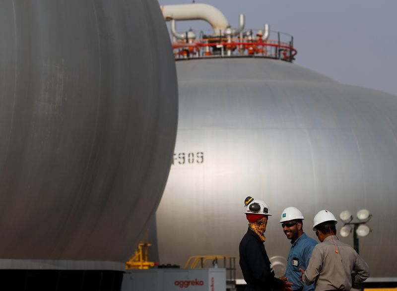 &copy; Reuters. FOTO DE ARCHIVO. Empleados hablan junto a esferoides en reconstrucción en las instalaciones petroleras de Saudi Aramco en Abqaiq, Arabia Saudita. 12 de octubre de 2019. REUTERS/Maxim Shemetov
