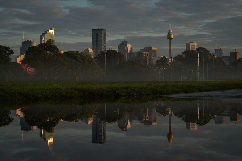 &copy; Reuters. FILE PHOTO: The city skyline is reflected in a puddle at sunrise following rainy weather in Sydney, Australia, August 28, 2022. REUTERS/Loren Elliott    