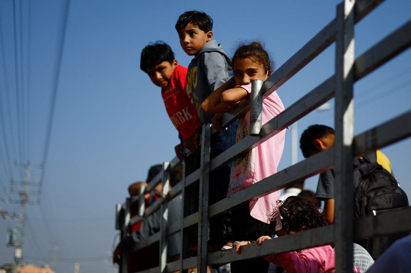 &copy; Reuters. أطفال تشاهد فلسطينيين يفرون من شمال غزة في التاسع من نوفمبر تشرين الثاني2023. تصوير: محمد سالم - رويترز.