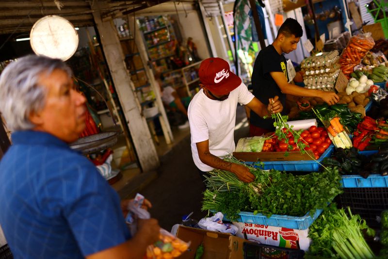 © Reuters. FILE PHOTO: Employees work at a stall in an outdoor market dedicated to the sale of fruits and vegetables, in Ciudad Juarez, Mexico July 27, 2023. REUTERS/Jose Luis Gonzalez/File Photo