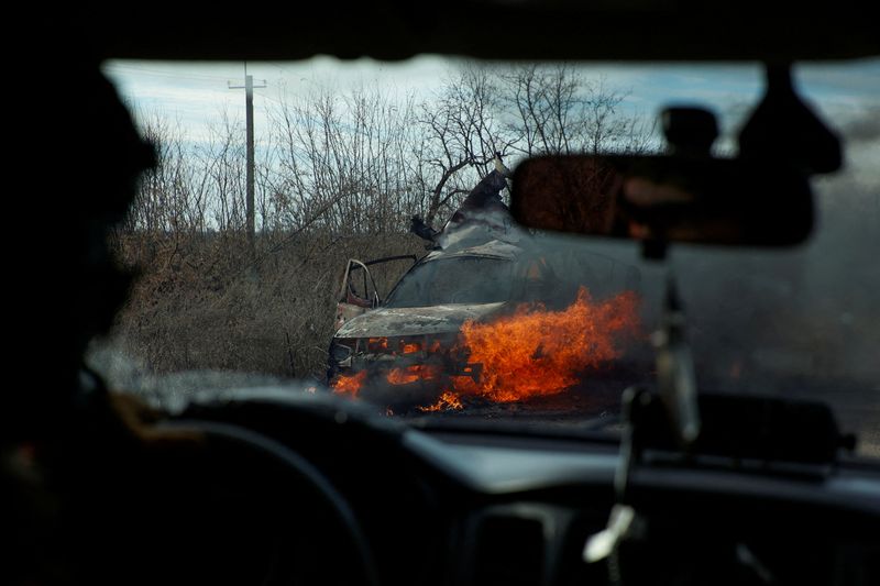 &copy; Reuters. FOTO DE ARCHIVO: Militares ucranianos pasan junto a un coche en llamas alcanzado por un dron kamikaze a las afueras de la ciudad de Avdivka, en primera línea del frente, en la región de Donetsk, Ucrania. 8 de noviembre de 2023. Radio Free Europe/Radio L
