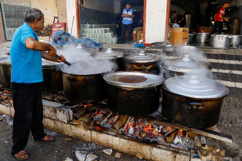 &copy; Reuters. Palestinos cozinham com lenha em Khan Younis, sul de Gaza
 5/11/2023   REUTERS/Ibraheem Abu Mustafa