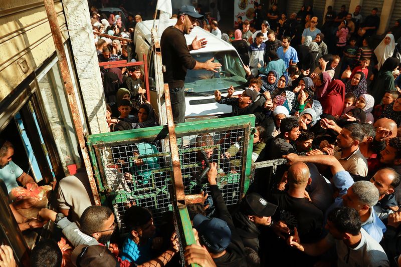 &copy; Reuters. فلسطينيون في خان يونس يتجمعون يوم الجمعة لشراء الخبز، وسط شح في الموارد الغذائية والوقود، مع احتدام الصراع بين إسرائيل وحركة (حماس) في قطاع 