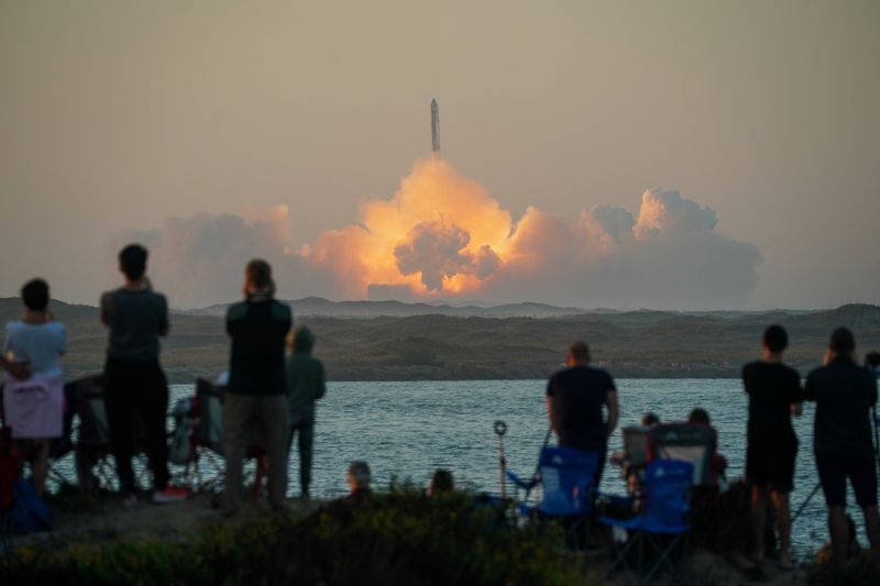 © Reuters. People watch as SpaceX's next-generation Starship spacecraft atop its powerful Super Heavy rocket lifts off from the company's Boca Chica launchpad on an uncrewed test flight, as seen from South Padre Island, near Brownsville, Texas, U.S. November 18, 2023. REUTERS/Go Nakamura