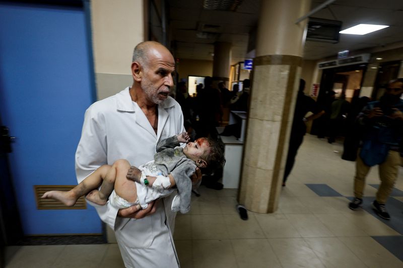 &copy; Reuters. أحد المسعفين في مستشفى ناصر في خان يونس بقطاع غزة يحمل طفلا أصيب في غارة إسرائيلية يوم السبت، وسط الصراع المستمر بين حركة حماس وإسرائيل. تصو