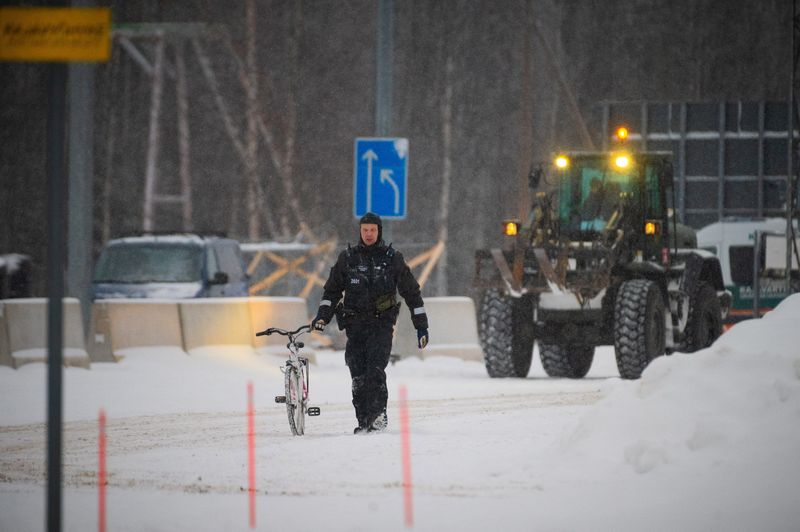 © Reuters. A border guard holds a bicycle of an asylum seeker at the Vartius border station in Kuhmo, Finland, November 19, 2023. Lehtikuva/Miska Puumala via REUTERS