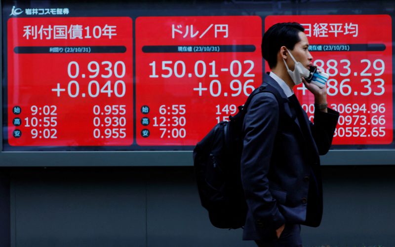 &copy; Reuters. FILE PHOTO: A man walks past an electronic board displaying Japan's 10-year government bonds level, the current Japanese Yen exchange rate against the U.S. dollar and Nikkei share average, outside a brokerage in Tokyo, Japan, October 31, 2023. REUTERS/Kim