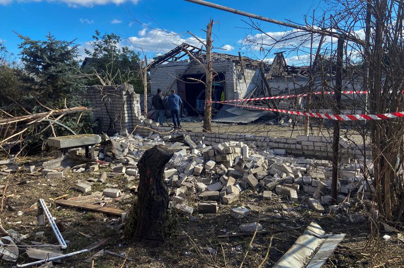 © Reuters. رجال من سكان المنطقة يقفون بجانب بجوار المباني السكنية التي تضررت بسبب ضربة جوية روسية في منطقة  دنيبروبتروفيسك بأوكرانيا يوم 18 أكتوبر تشرين الأول 2023. تصوير : ميكولا سنيلنيكوف - رويترز.