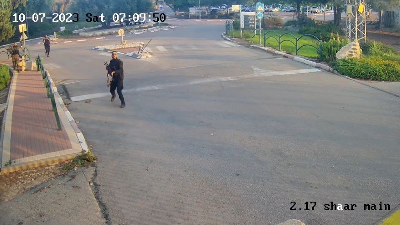 © Reuters. Armed men run holding guns during the October 7 attack by Hamas, in this screen grab from footage captured by a surveillance camera in Kibbutz Alumim, Israel, and released November 20, 2023. South First Responders/Handout via REUTERS    