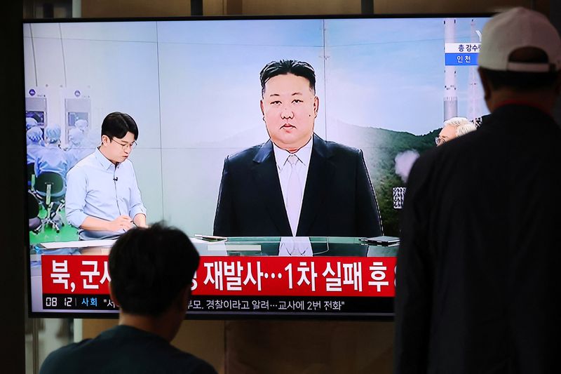 &copy; Reuters. FILE PHOTO: Passengers watch a TV broadcasting a news report on North Korea firing a space rocket, at a railway station in Seoul, South Korea, August 24, 2023.    REUTERS/Kim Hong-Ji/File photo