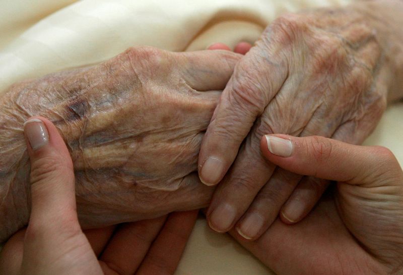 &copy; Reuters. FILE PHOTO: A young carer holds the hands of an elderly woman in a residential home for the elderly in Planegg near Munich June 19, 2007. REUTERS/Michaela Rehle (GERMANY)/File Photo