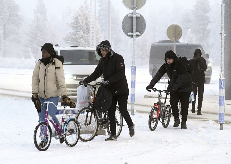 &copy; Reuters. Varios inmigrantes cruzan con bicicletas el paso fronterizo de Salla, Finlandia. 21 noviembre 2023. Lehtikuva/Jussi Nukari vía Reuters. ATENCIÓN EDITORES - ESTA IMAGEN FUE ENTREGADA POR UNA TERCERA PARTE. NO REVENTAS A TERCEROS.