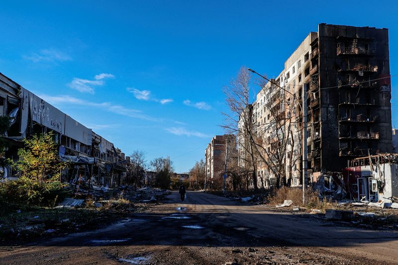 &copy; Reuters. مواطن محلي يسير إلى جانب مبان سكنية متضررة جراء قصف عنيف من القوات الروسية في بلدة أفديفكا بخط المواجهة في منطقة دونيتسك الأوكرانية يوم الث