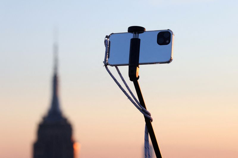 &copy; Reuters. FILE PHOTO: A smartphone is seen on a selfie stick in Manhattan, in New York City, New York U.S., February 11, 2022. REUTERS/Andrew Kelly/File Photo
