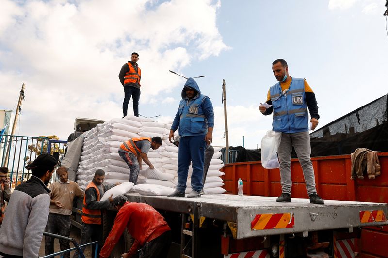 &copy; Reuters. Palestinians receive flour bags distributed by UNRWA in Rafah, in the southern Gaza Strip November 21, 2023. REUTERS/Ibraheem Abu Mustafa