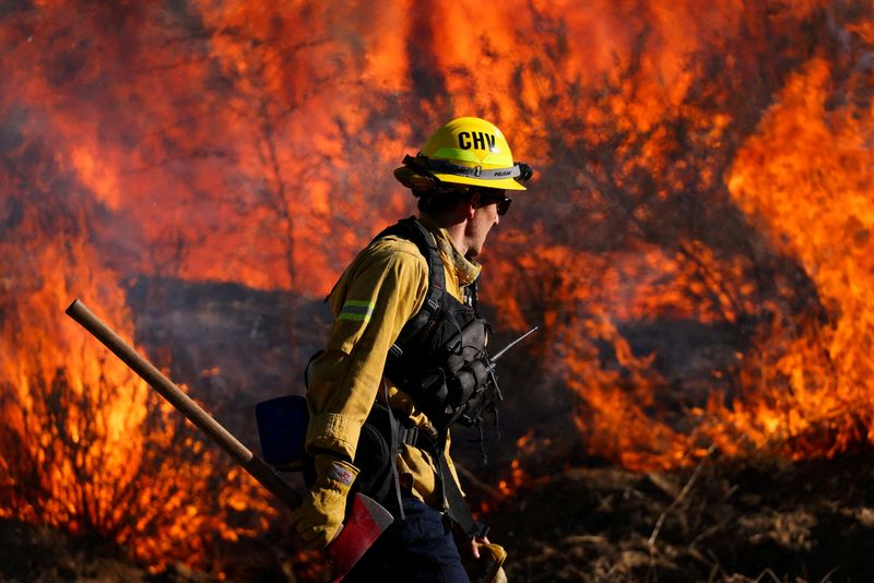 &copy; Reuters. FILE PHOTO: A firefighter works to extinguish the Highland Fire, a wind driven wildfire near Aguanga, California, U.S., October 31, 2023.  REUTERS/Mike Blake/File Photo