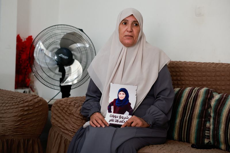 &copy; Reuters. سميرة دويات وهي تحمل صورة ابنتها الأسيرة الفلسطينية شروق دويات التي تبلغ من العمر 26 عاما والتي حكم عليها بالسجن لمدة 16 عاما في القدس يوم الأ
