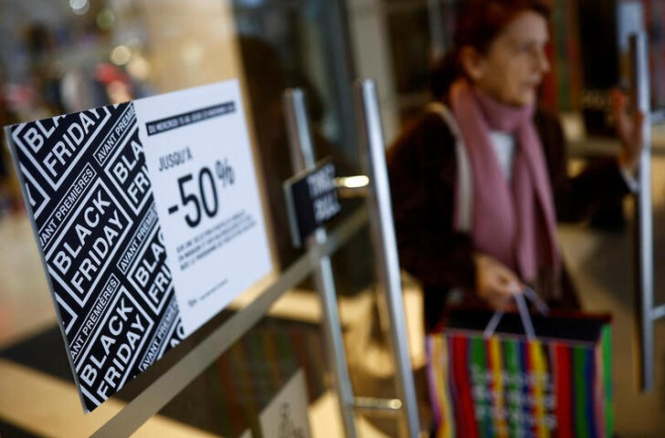 © Reuters. A woman walks past a Black Friday sale sign on a shop door in Nantes, France, November 21, 2023. REUTERS/Stephane Mahe