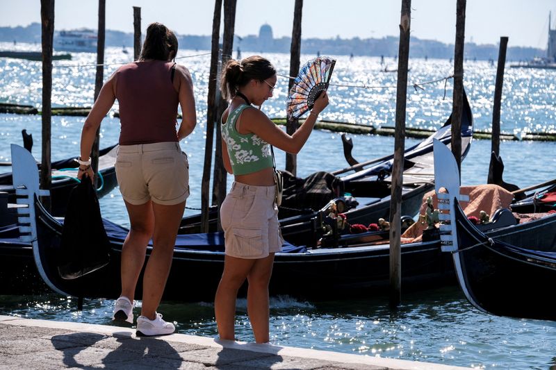 &copy; Reuters. Imagen de archivo de turistas junto a un embarcadero de góndolas en un canal de Venecia, Italia. 22 agosto 2023. REUTERS/Manuel Silvestri