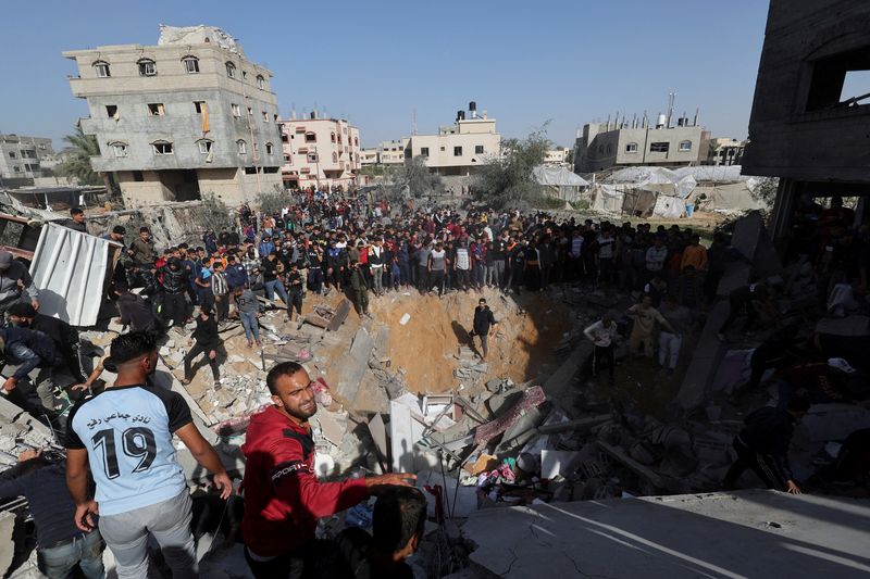 &copy; Reuters. Palestinos se reúnen mientras otros buscan víctimas en el lugar de un ataque israelí contra una casa en Rafah, en medio del conflicto en curso entre Israel y el grupo islamista palestino Hamás, en el sur de la Franja de Gaza. 23 de noviembre 2023. REU