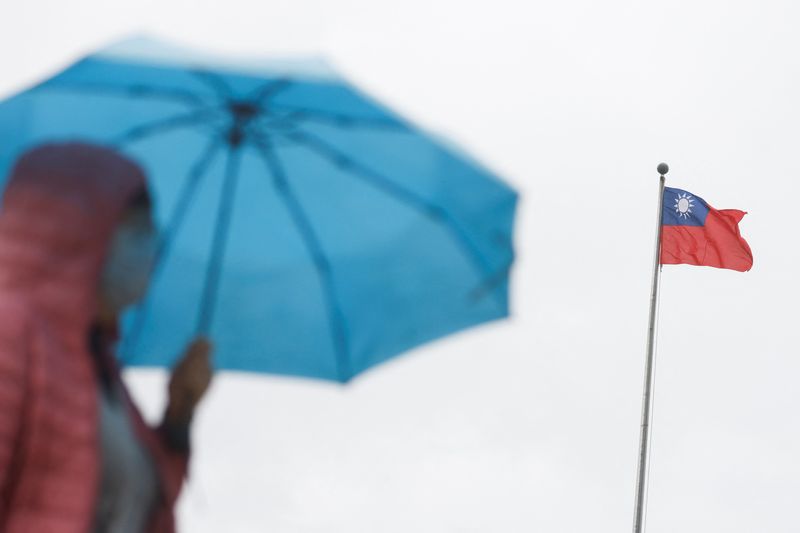 &copy; Reuters. Mulher segura guarda-chuva perto de bandeira de Taiwan, em Taipé
16/11/2023 REUTERS/Carlos Garcia Rawlins