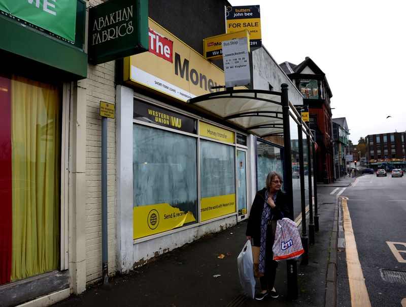 &copy; Reuters. A woman with shopping bags waits for a bus, Hanley, Britain, November 20, 2023. REUTERS/Carl Recine/File Photo
