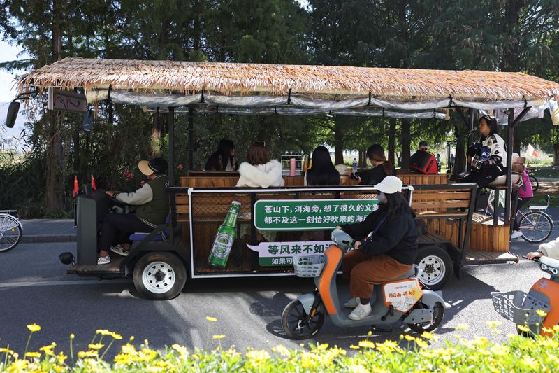 © Reuters. A man sings for customers touring the Erhai lake on a sightseeing bus, in Dali, Yunnan province, China November 10, 2023. REUTERS/Florence Lo