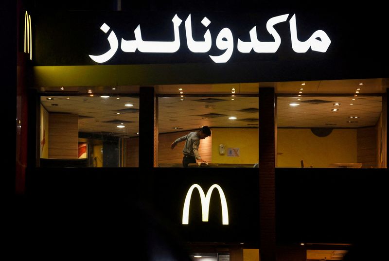 &copy; Reuters. 　１１月２２日、最近のエジプト首都カイロのある夜、客がまったくいないマクドナルドの店舗で従業員がテーブルを掃除する光景が見られた。写真はカイロのマクドナルド店舗。２０日撮