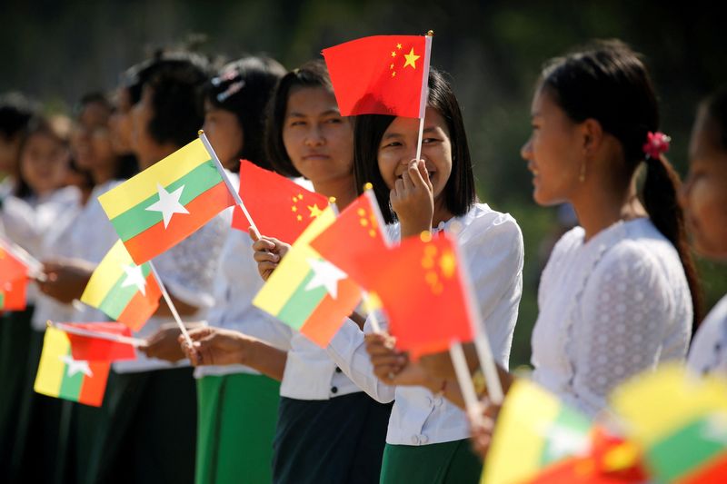 &copy; Reuters. FILE PHOTO: Myanmar students hold Myanmar and Chinese flags as they prepare to welcome Chinese President Xi Jinping outside of the airport in Naypyitaw, Myanmar, January 17, 2020. REUTERS/Ann Wang/File Photo