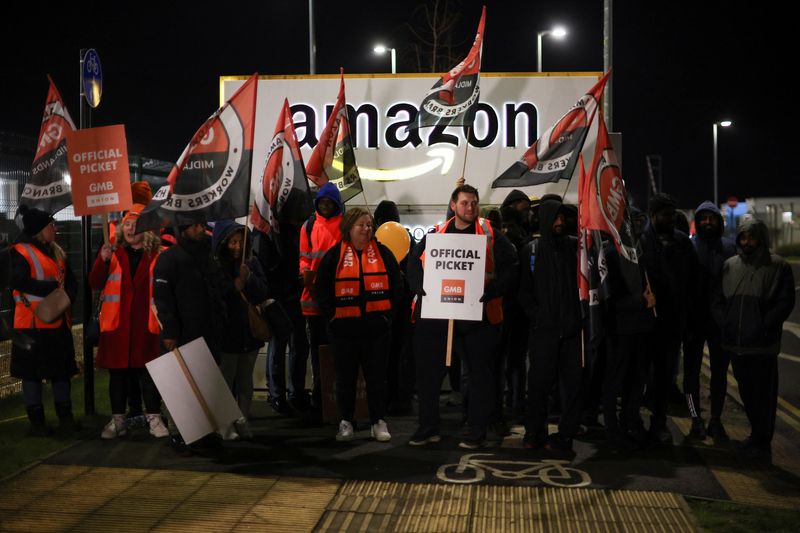 &copy; Reuters. Des personnes brandissent des pancartes lors d'une mobilisation devant l'entrepôt d'Amazon dans la ville anglaise de Coventry à l'occasion du Black Friday. /Photo prise le 24 novembre 2023/REUTERS/Phil Noble 