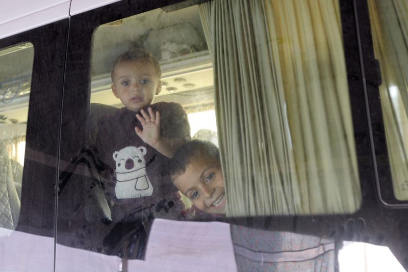 &copy; Reuters. Bambini palestinesi sfollati, fuggiti dalle loro case con la famiglia a causa degli attacchi israeliani, guardano fuori dal veicolo in cui si sono rifugiati, durante il conflitto in corso tra Israele e il gruppo islamista palestinese Hamas, all'ospedale N