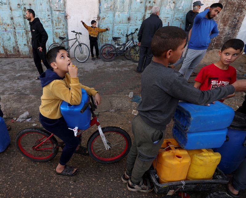 &copy; Reuters. Niños palestinos esperando en una fila con bidones para recoger agua, en un contexto de escasez de agua potable, en Rafah, en el sur de la Franja de Gaza. 23 de noviembre de 2023. REUTERS/Ibraheem Abu Mustafa