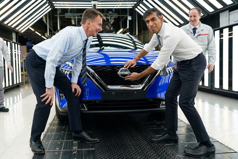 © Reuters. Britain's Prime Minister Rishi Sunak and Chancellor of the Exchequer Jeremy Hunt attach a Nissan badge to a car as they visit the car manufacturer, Nissan, in Sunderland, Britain, November 24, 2023. The Prime Minister and Chancellor visited the Japanese car manufacturer as they announced they will build three new electric car models at its plant in Sunderland as part of a ?2 billion investment.  Ian Forsyth/Pool via REUTERS